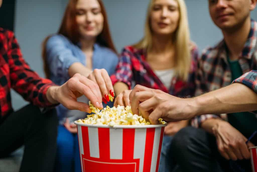 Group of people eating popcorn in cinema